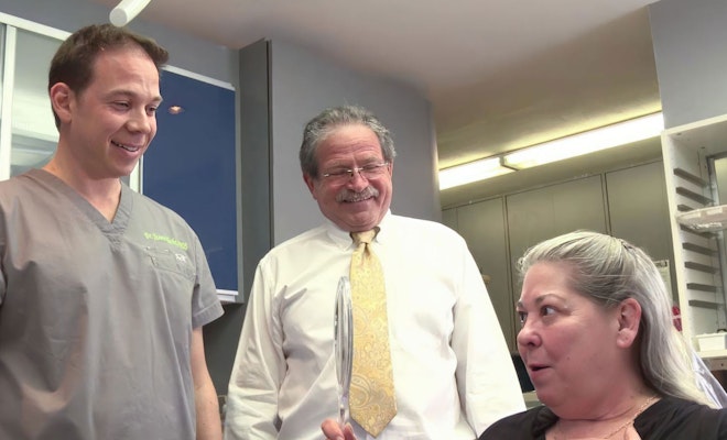 Patient looking at smile with dentists