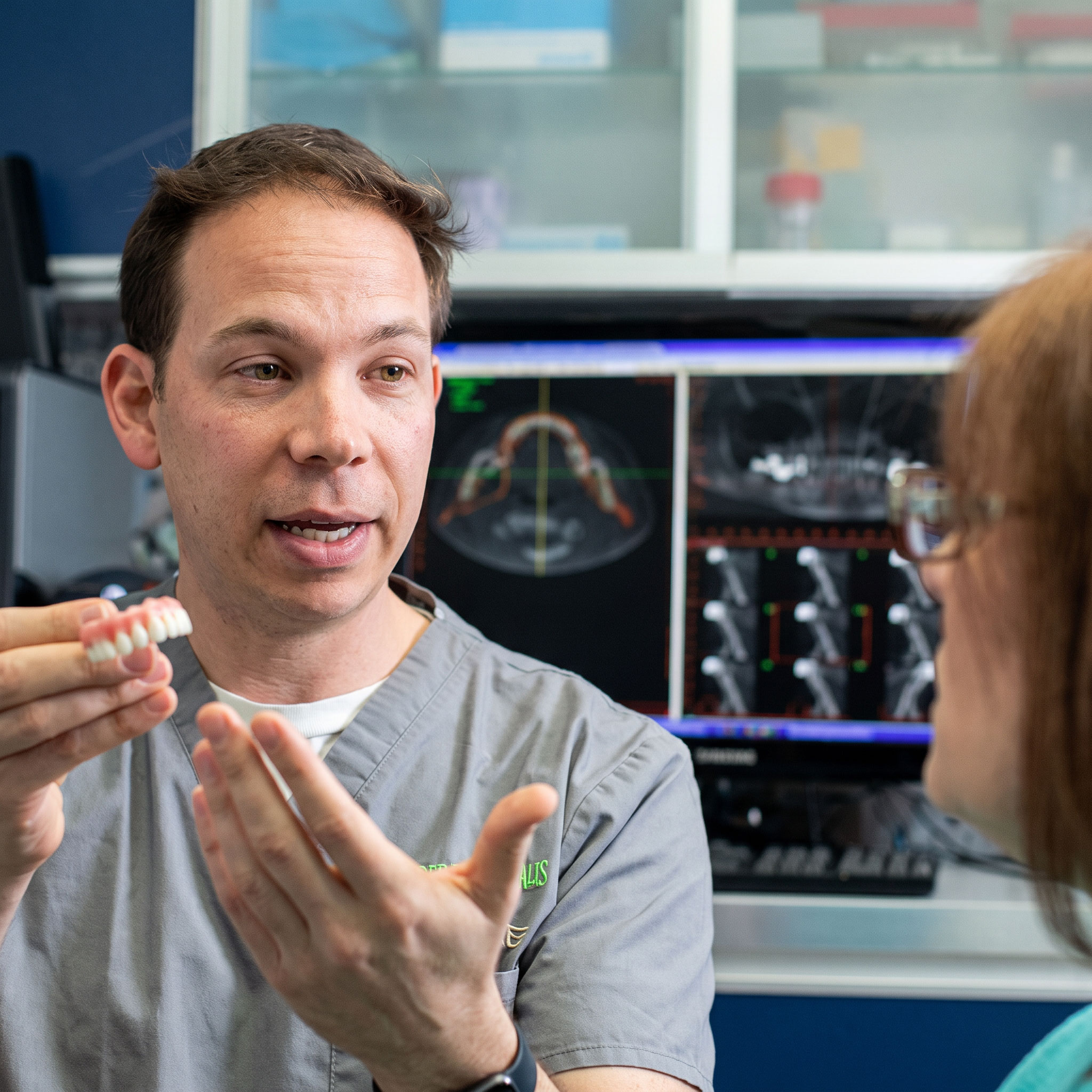 Dr showing implant model to patient