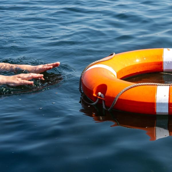Hands Reaching for Life Ring in Water