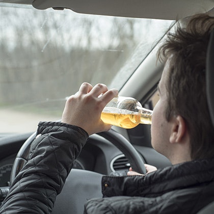 Driver drinking a beer bottle