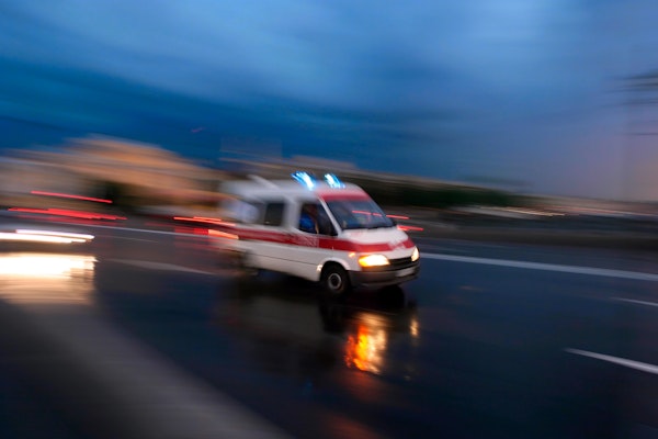Blurred ambulance speeding towards scene of a motorcycle crash