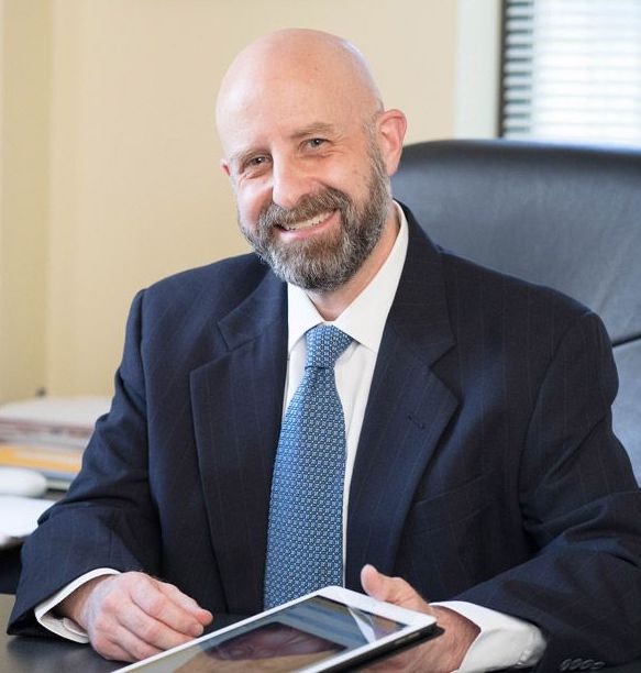 Dr. Hove in front of office window