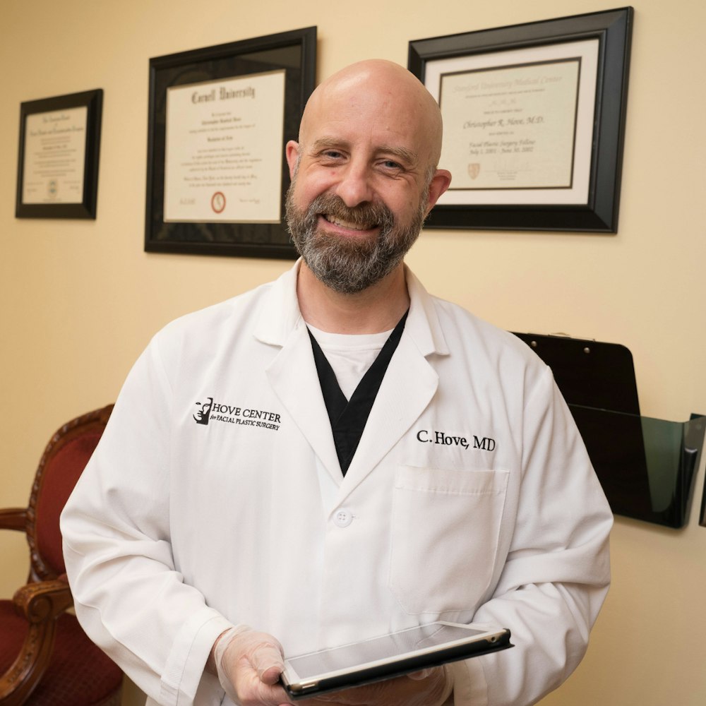 Dr. Hove smiling in front of his degrees