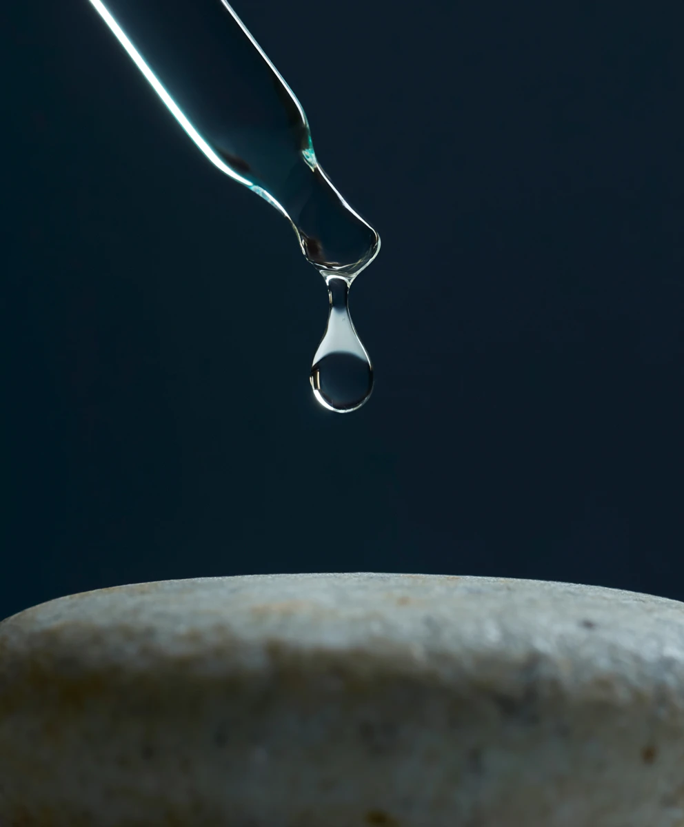 dropper dropping chemical peel solution on a stone