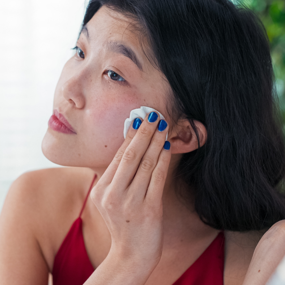Woman applying cleanser to face