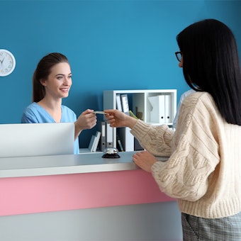 a woman paying a dental practice