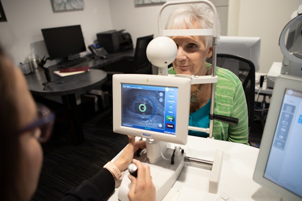 Woman undergoing eye exam using advanced technology