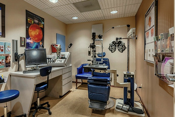 Eye exam room at Arizona Eye Institute featuring a slit lamp, phoropter, and patient chair
