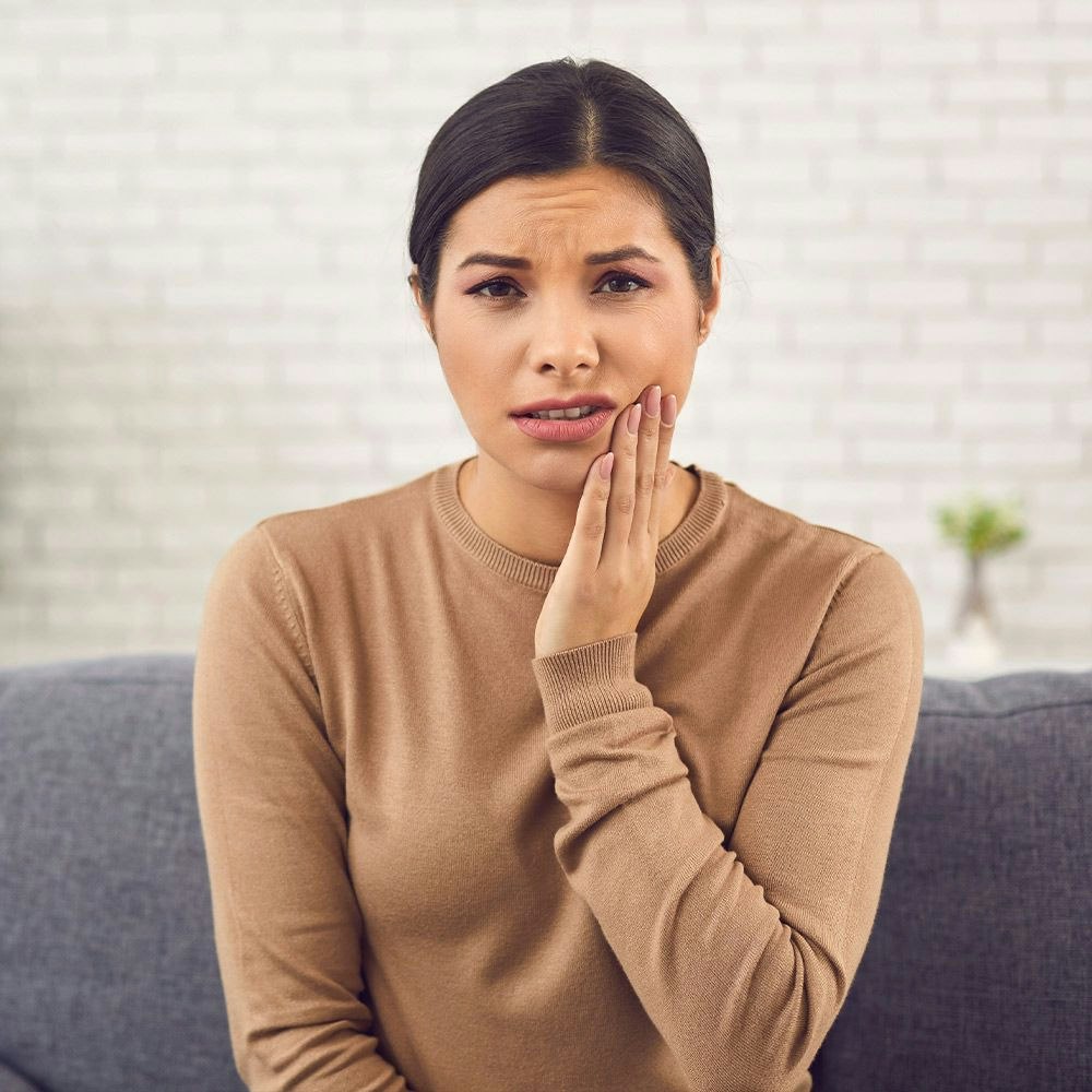 Woman holding jaw in pain