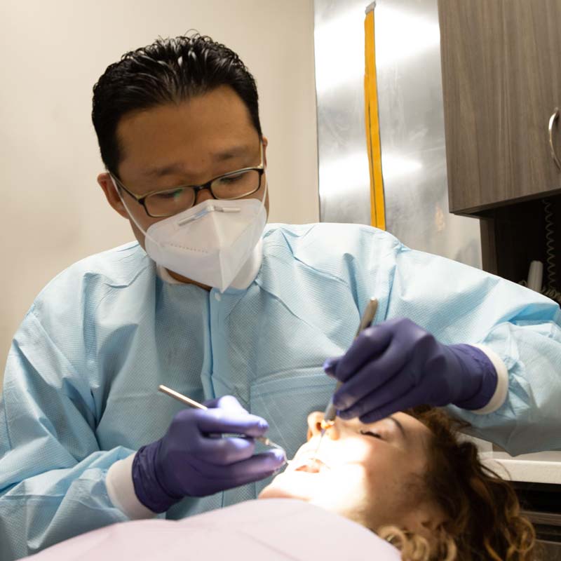 Dr. Joung performing dental operation on patient