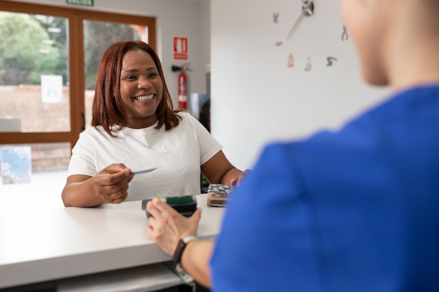 a woman paying the dentist