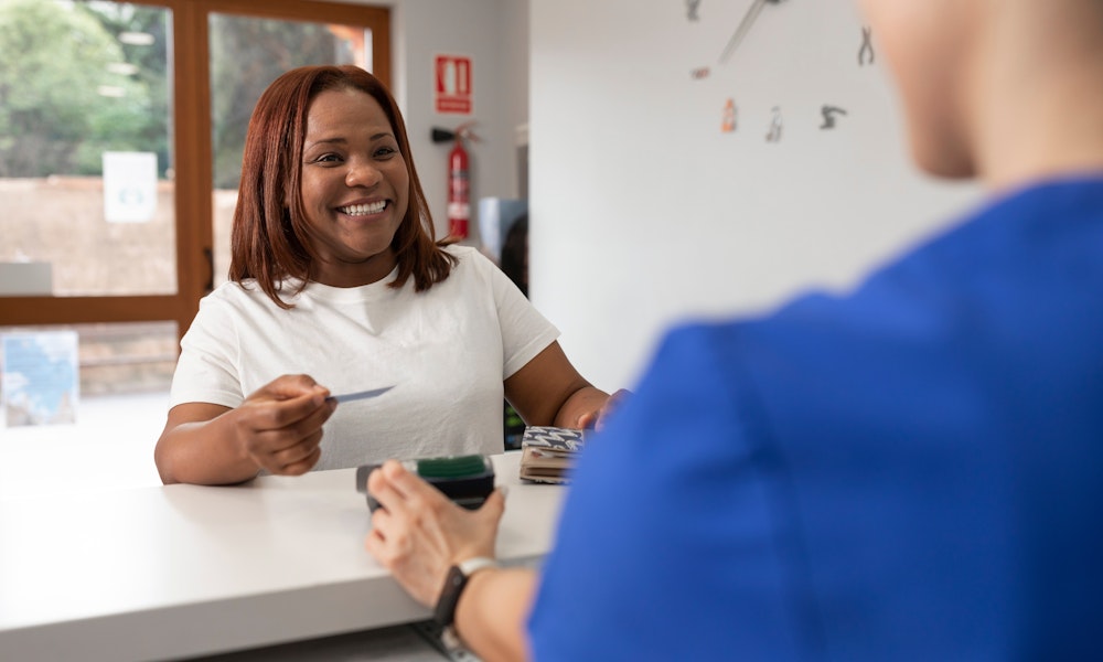 a woman paying the dentist