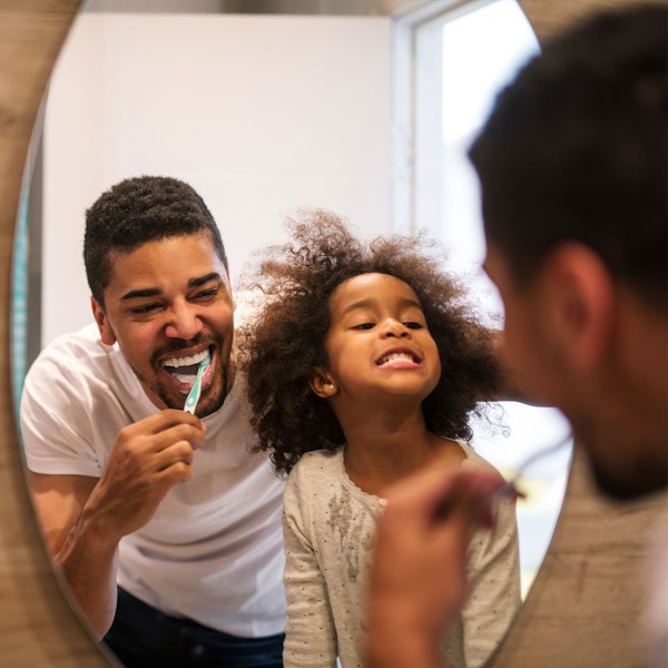 Daughter and dad brushing teeth