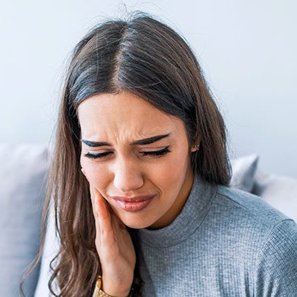 Young woman clutching side of face