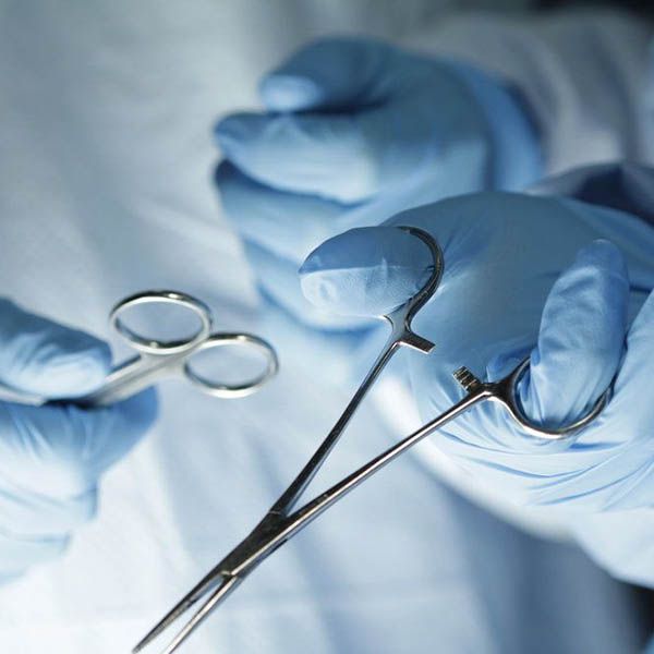 a closeup of surgical tools in gloved hands