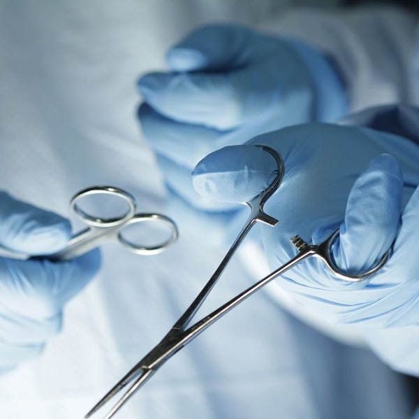 a closeup of surgical tools in gloved hands