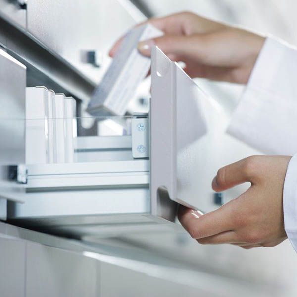 a pharmacist removing medication from a drawer