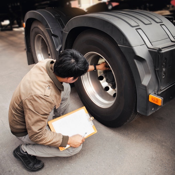 Inspector looking at truck wheels