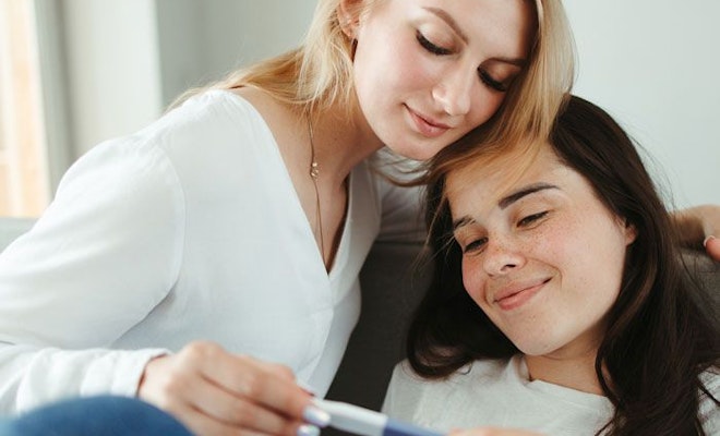 Two women looking at pregnancy test