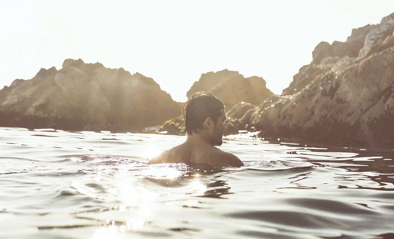 a man swimming in monterey coast