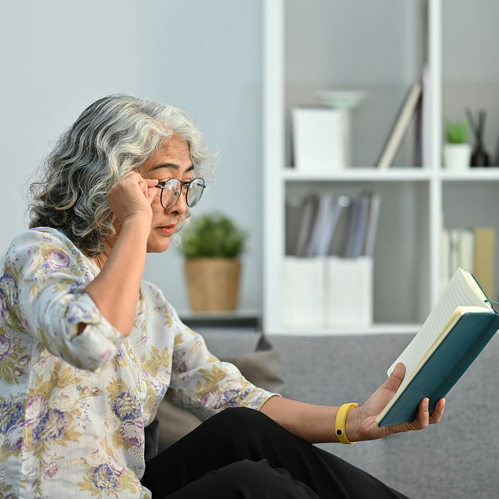 Woman holding book at arm's length