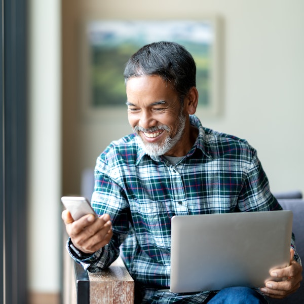 Happy, mature man looking at his phone