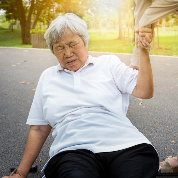 Mature woman being helped up after falling down