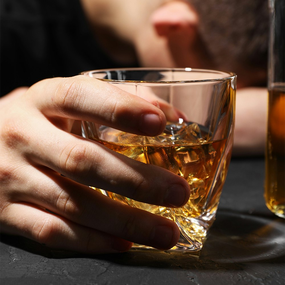 a hand holding an alcoholic beverage