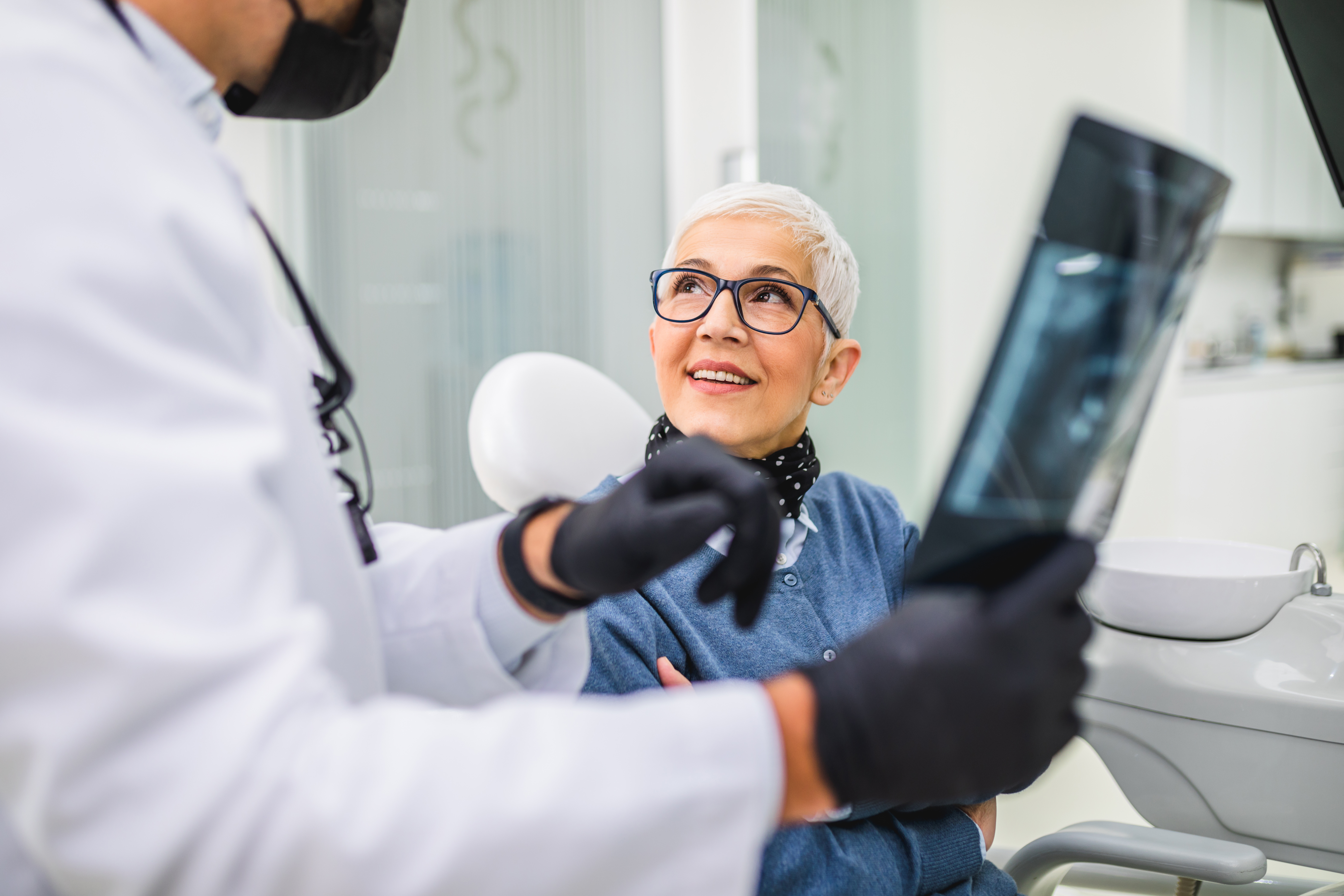 older woman smiling at dental team