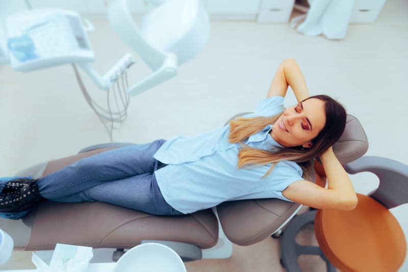 women lying back in dental chair smiling