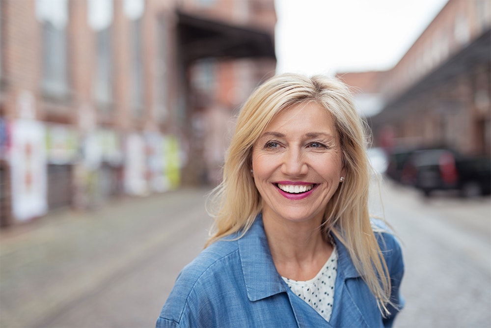 Mature blonde woman with dental implants smiling