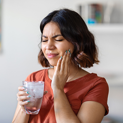 woman holding jaw in pain