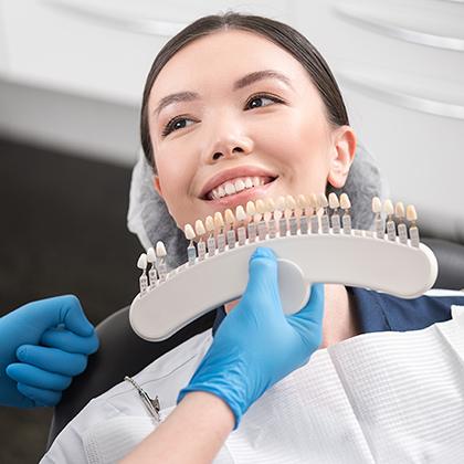 patient comparing tooth shades for whitening procedure