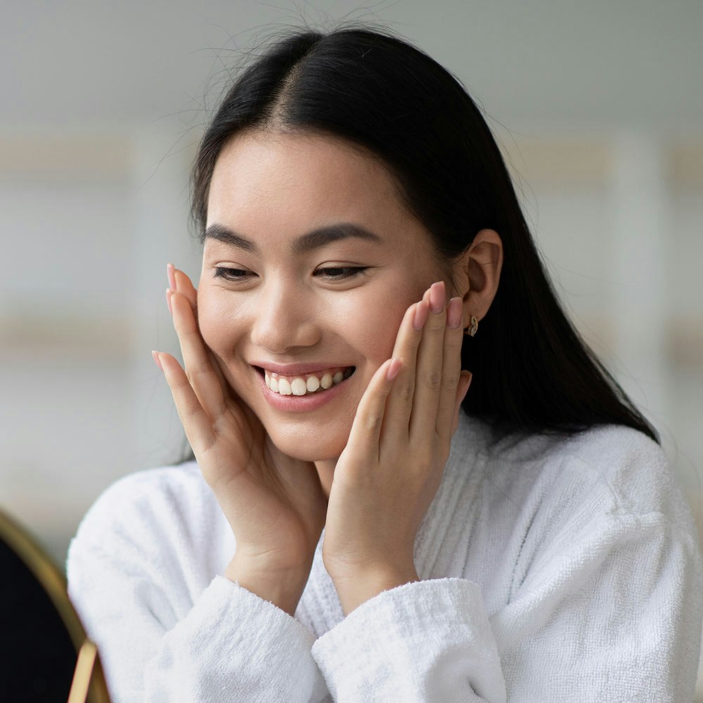 woman looking happily into the mirror