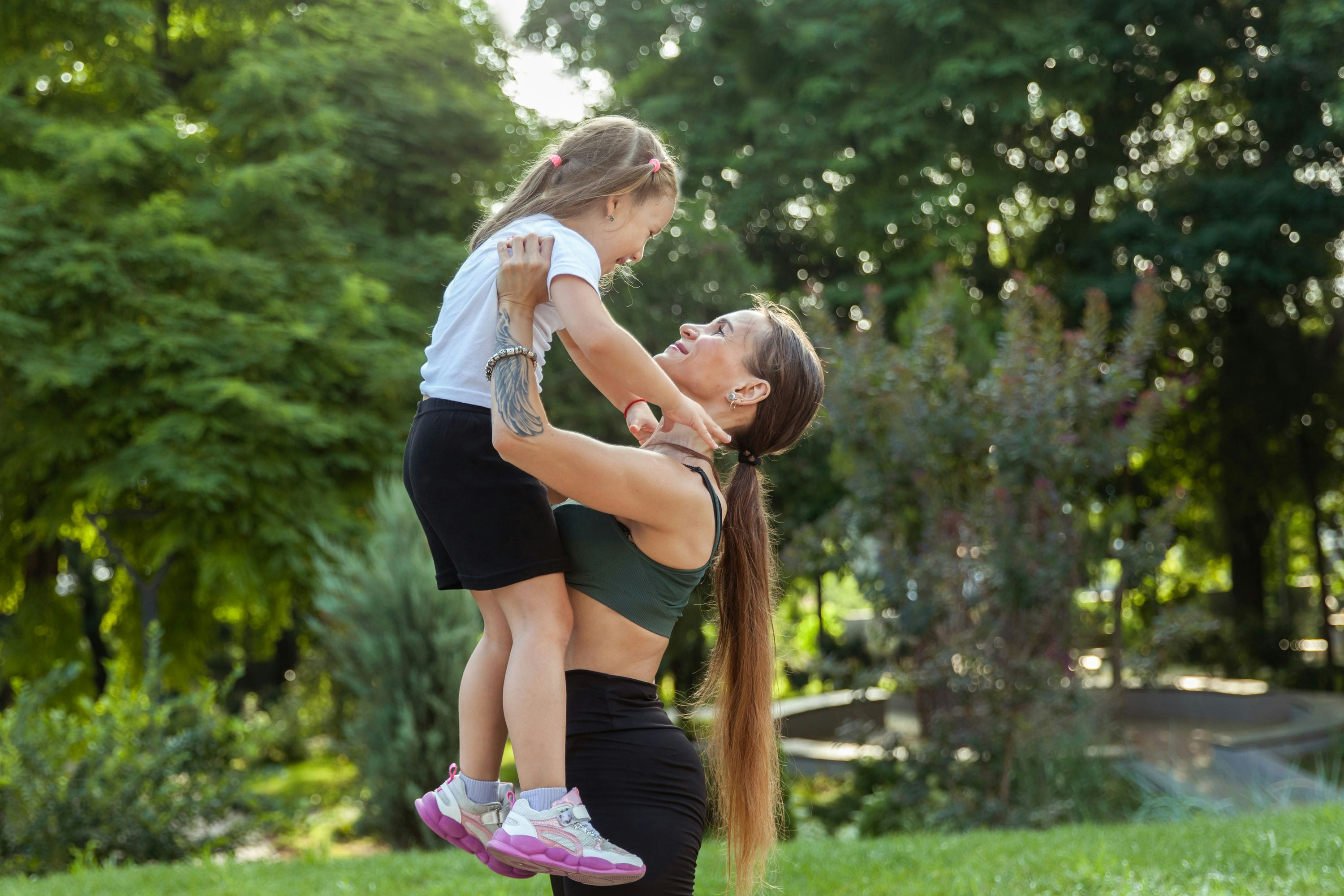 Mother lifting up daughter after working out