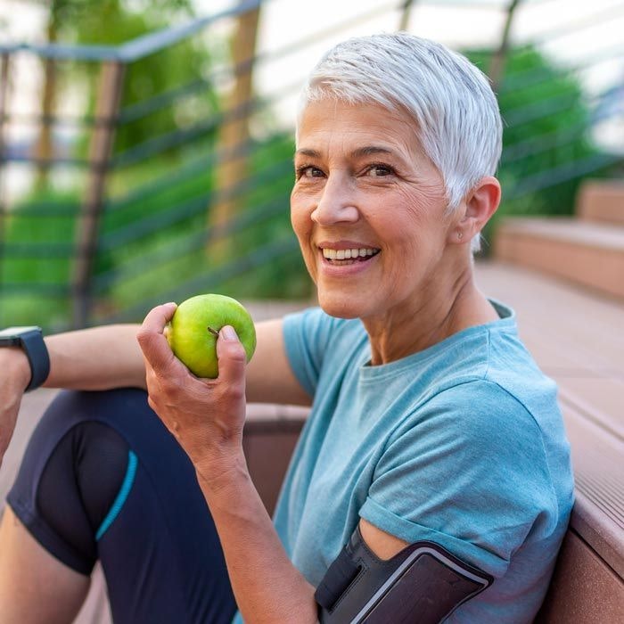 Smiling lady eating apple