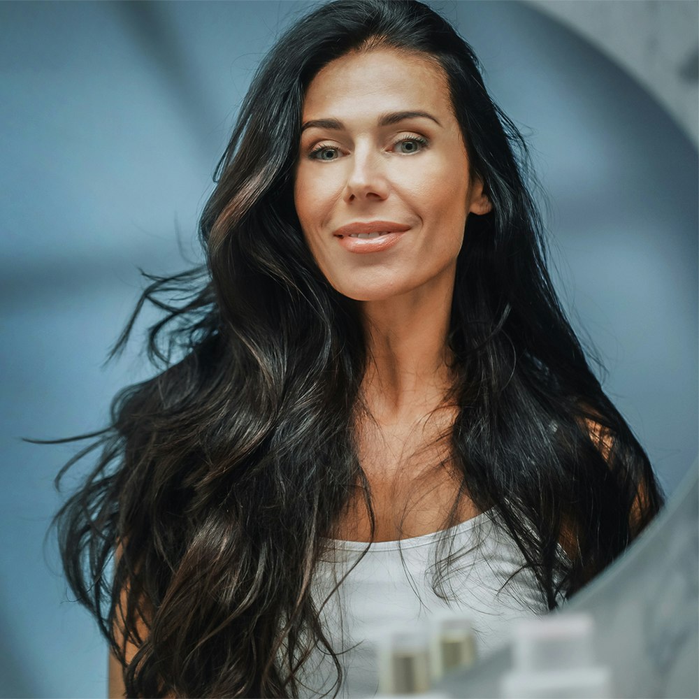 Middle-aged woman smiling while looking in the mirror