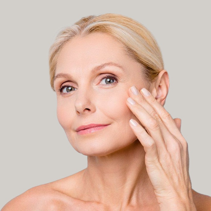 mature woman touching face