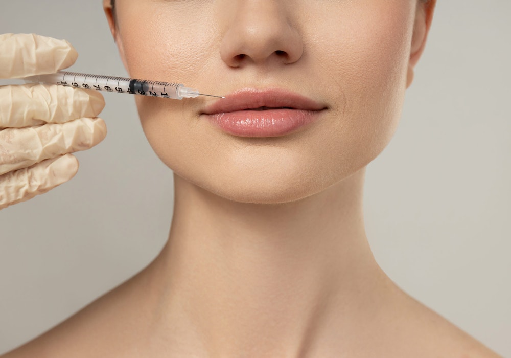 aesthetician preparing botox injection for woman