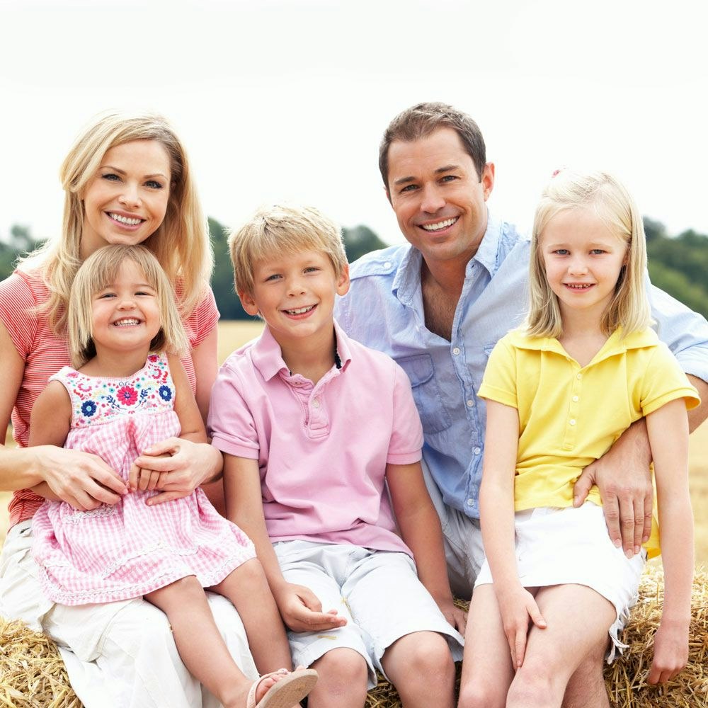 smiling parents with two young girls and one young boy