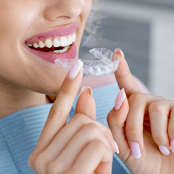Woman putting clear aligner in