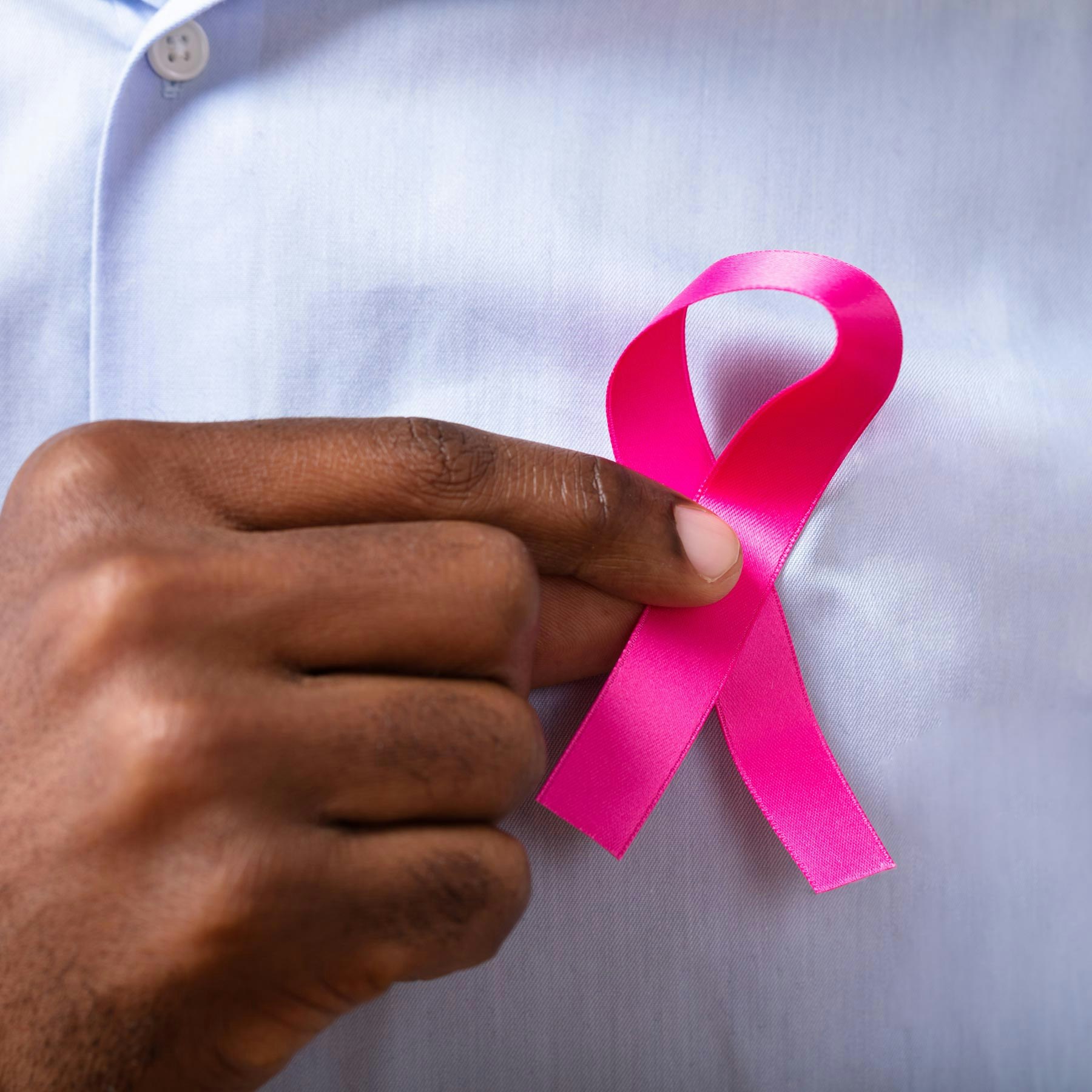 man holding breast cancer ribbon