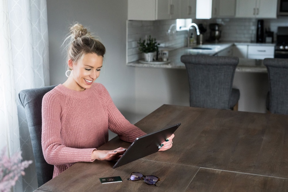 Excited woman considering breast augmentation and looking at photo gallery of results