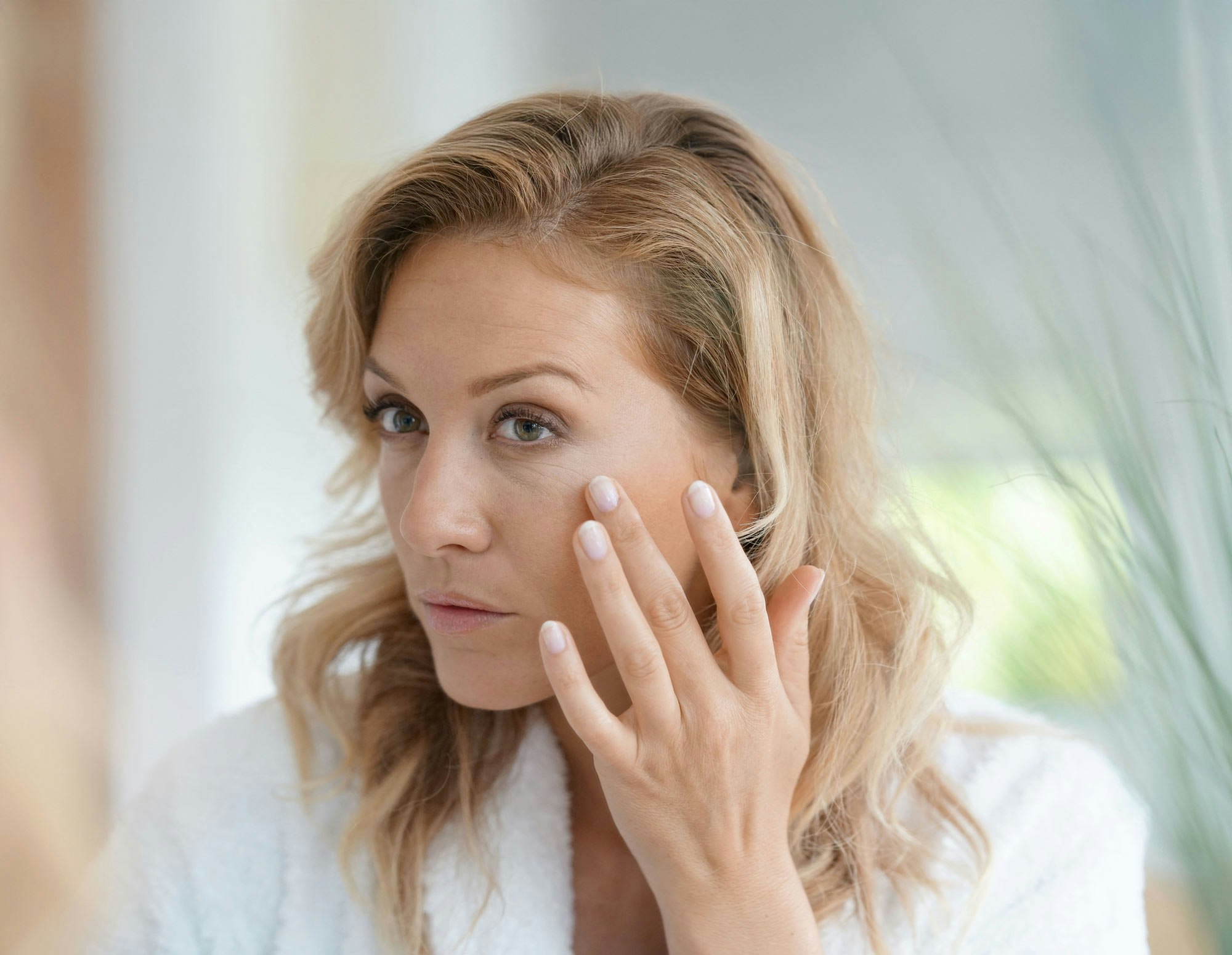 woman examining her face