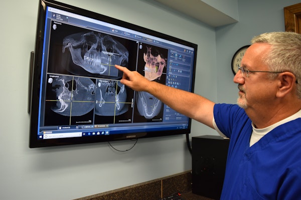 Dr. Lande pointing to dental x-rays