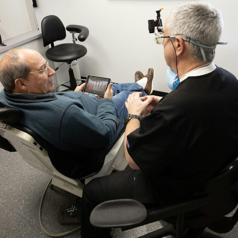 Dr. Lande showing patient what dental implants look like