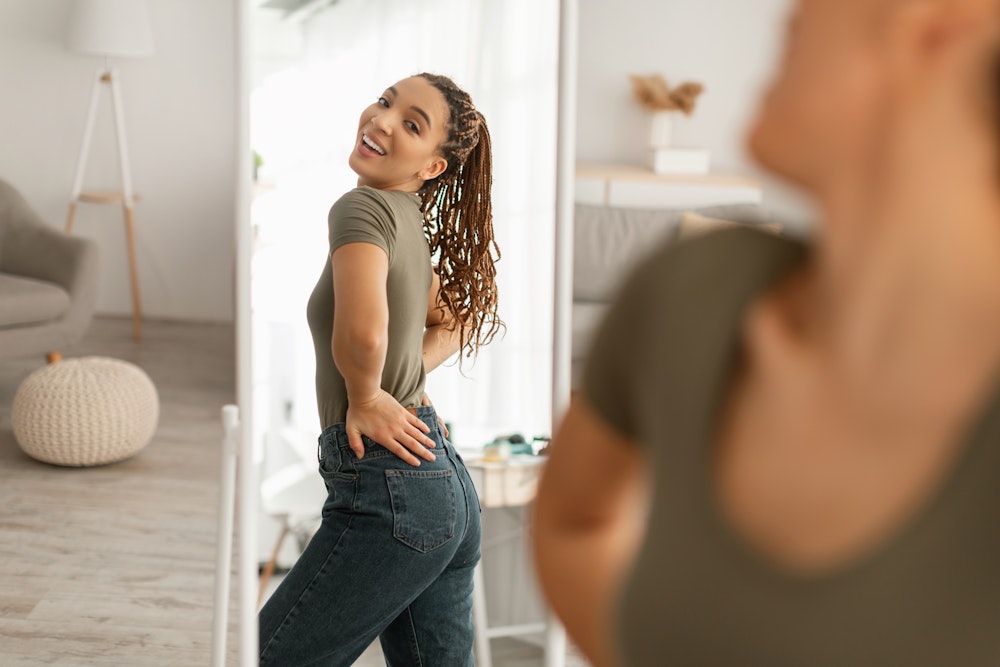 Woman admiring her reflection in full length mirror