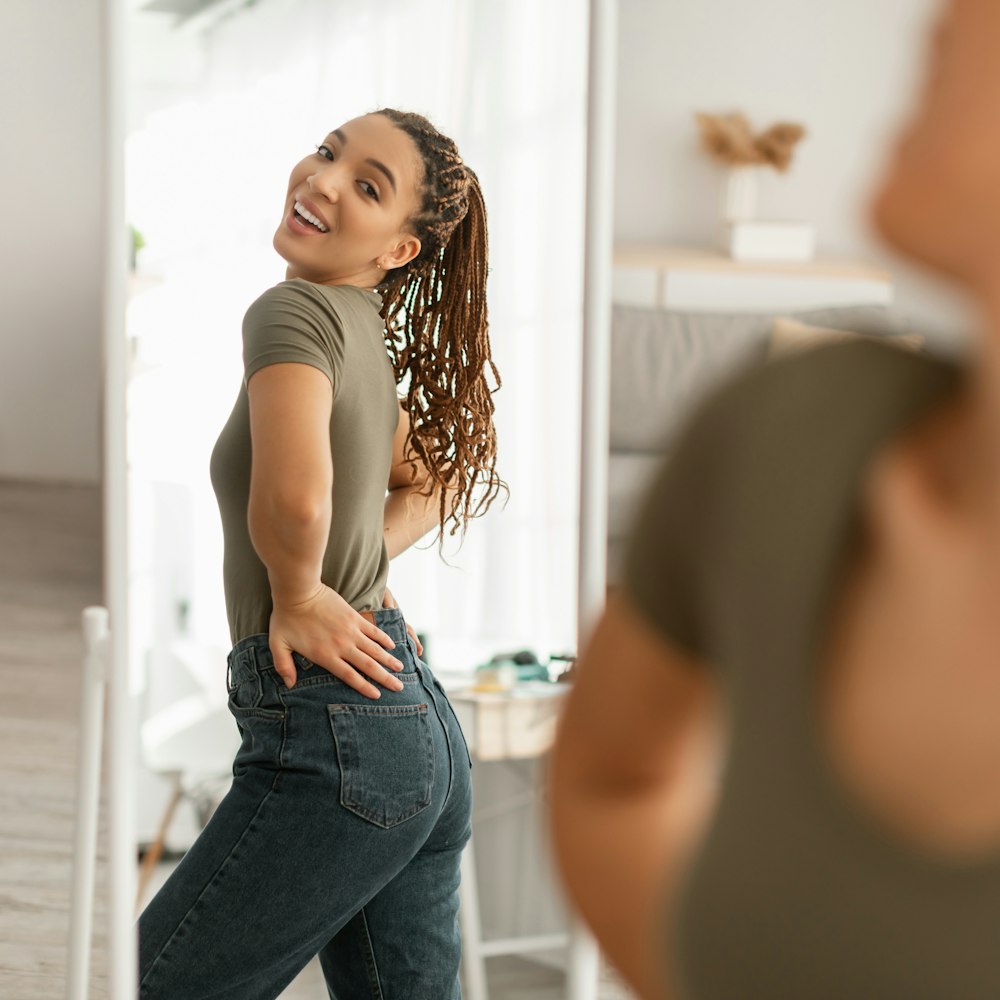Woman admiring her reflection in full length mirror
