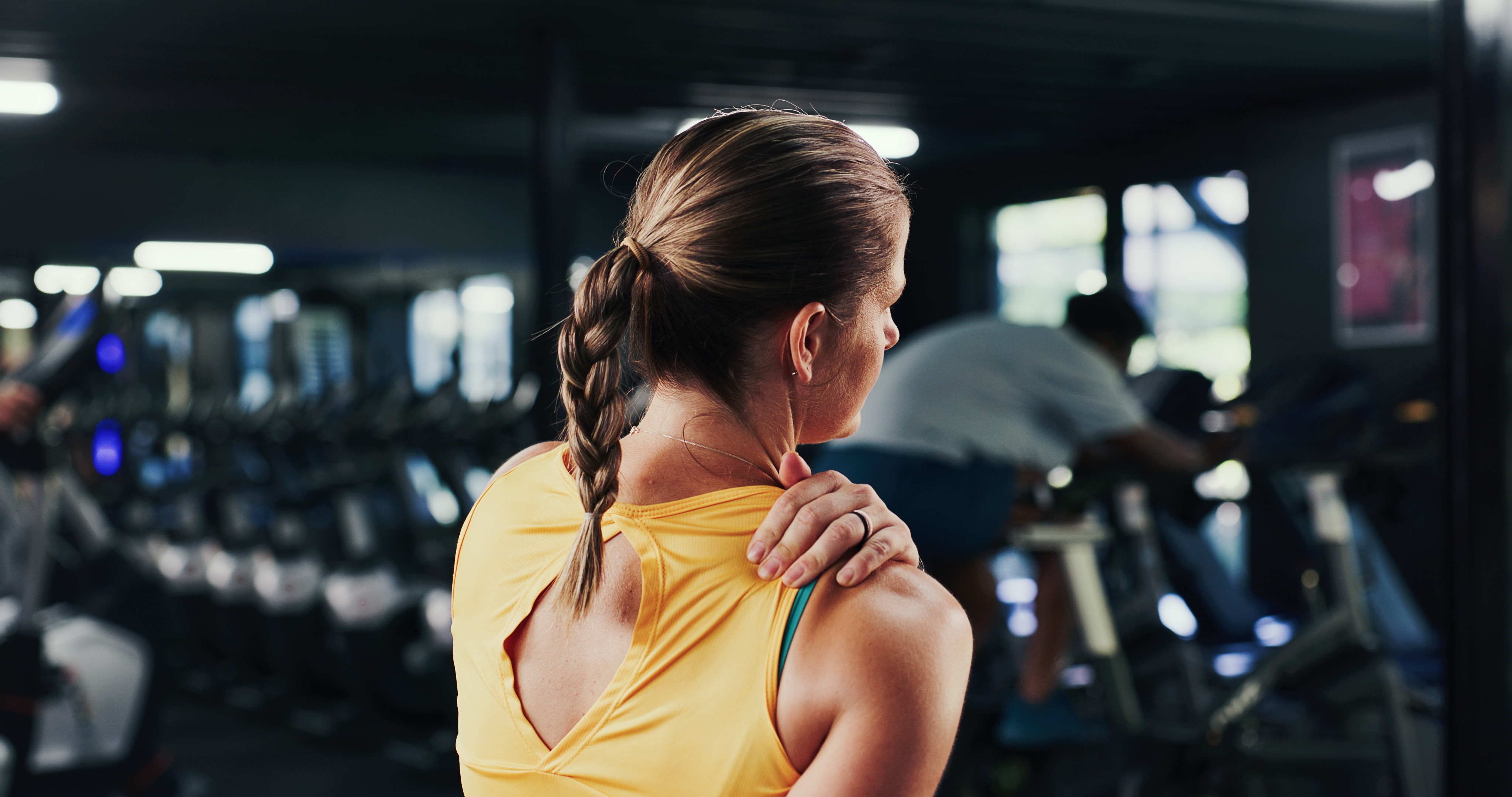 woman holding her shoulder in pain