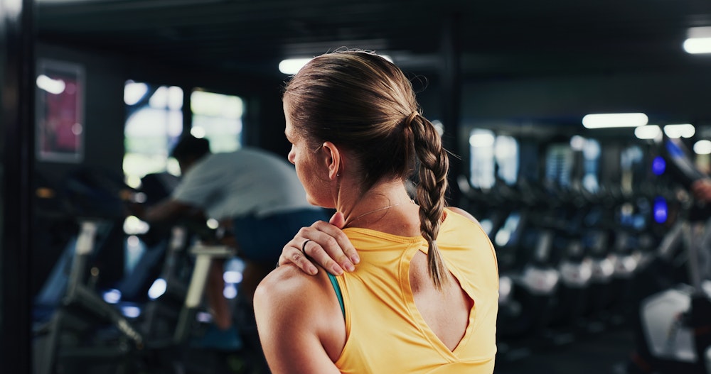 woman holding her shoulder in pain
